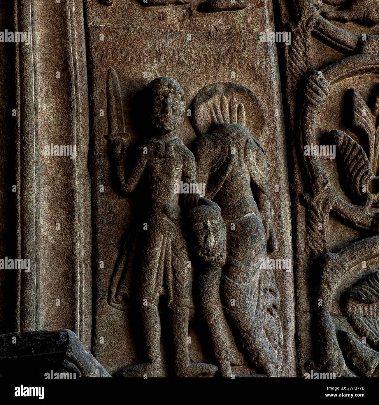 Décapitation de Saint Paul l'Apôtre. Sculpté en relief au milieu des années 1100 dans le style roman lombard à l'entrée de la basilique du monastère de Santa Maria de Ripoll dans la province de Gérone, Catalogne, Espagne. Le bourreau tient la tête de Saint Paul dans sa main gauche et l'épée dans sa main droite. Le corps sans tête de Saint Paul, le sang jaillit du cou, est à droite du bourreau. Selon la tradition, Saint Paul l'Apôtre (c. 4 EC à c. 64 EC) a été décapité à Rome et est mort en martyr pour sa foi chrétienne. Banque D'Images