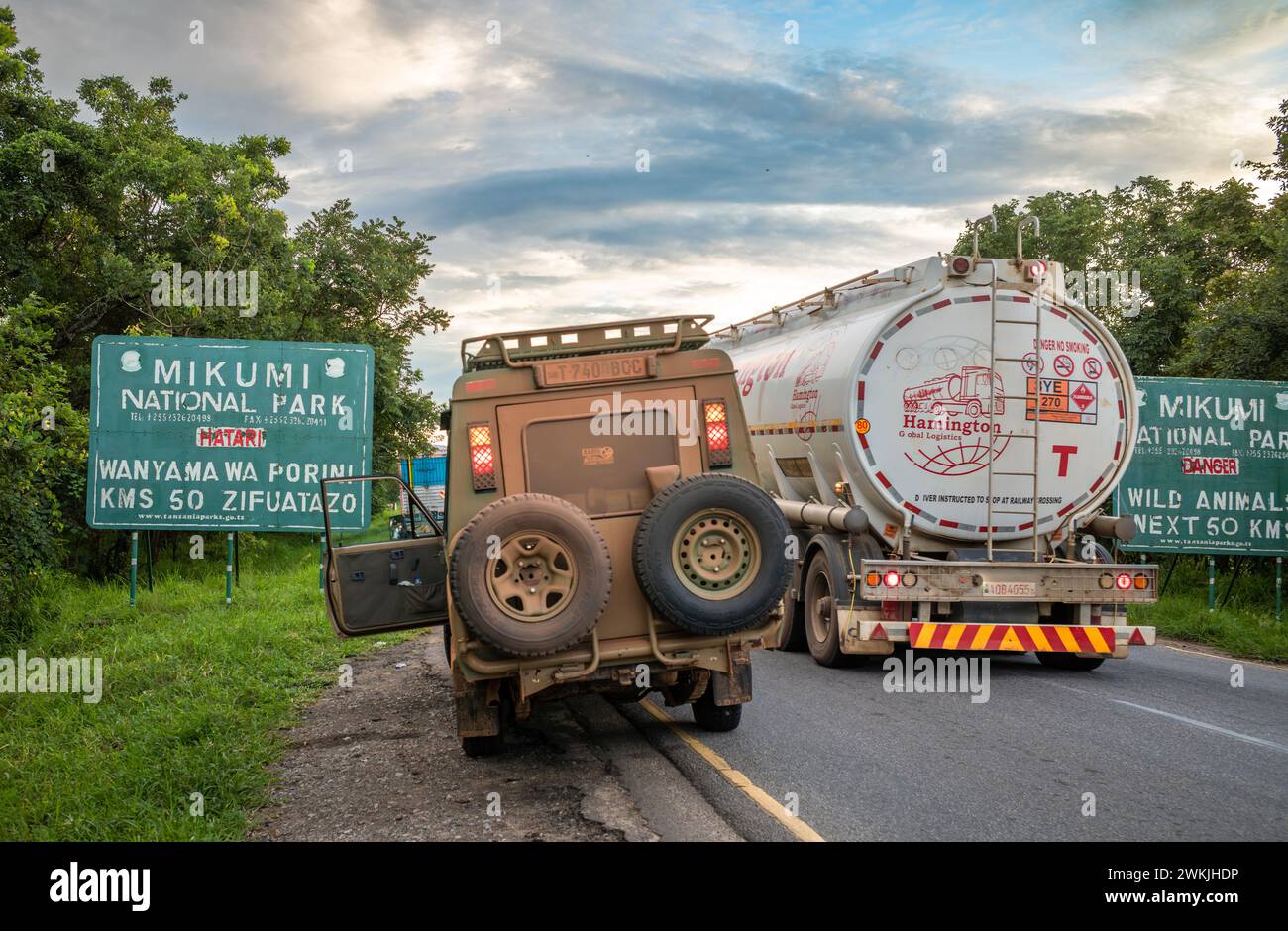Un camion et un véhicule 4x4 sur l'autoroute A7 près du panneau d'entrée du parc national de Mikumi en Tanzanie Banque D'Images Un camion et un véhicule 4x4 sur l'autoroute A7 près du panneau d'entrée du parc national de Mikumi en Tanzanie Banque D'Images