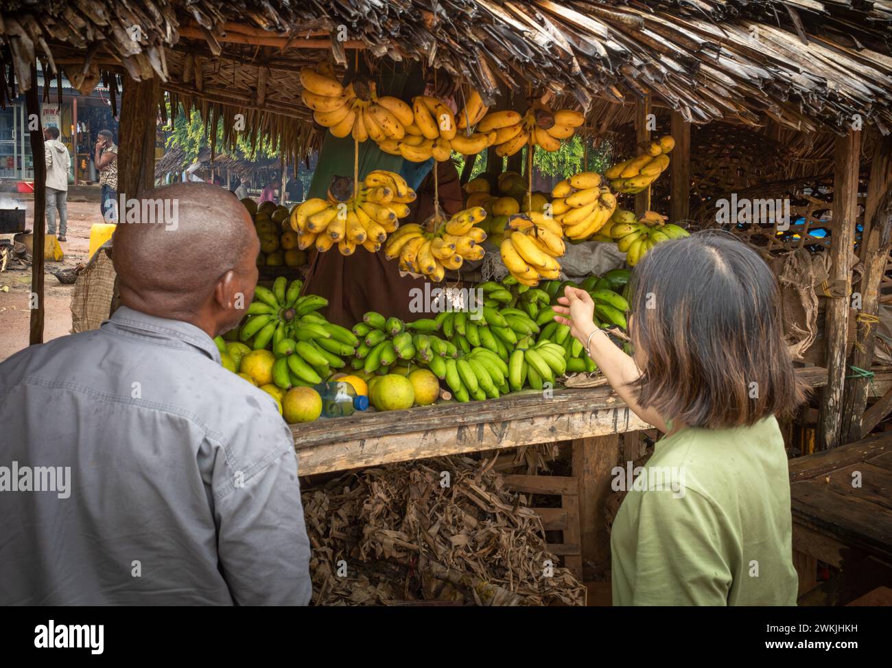 Une touriste étrangère et son guide local achètent des bananes au marché de Msanga, en Tanzanie rurale Banque D'Images