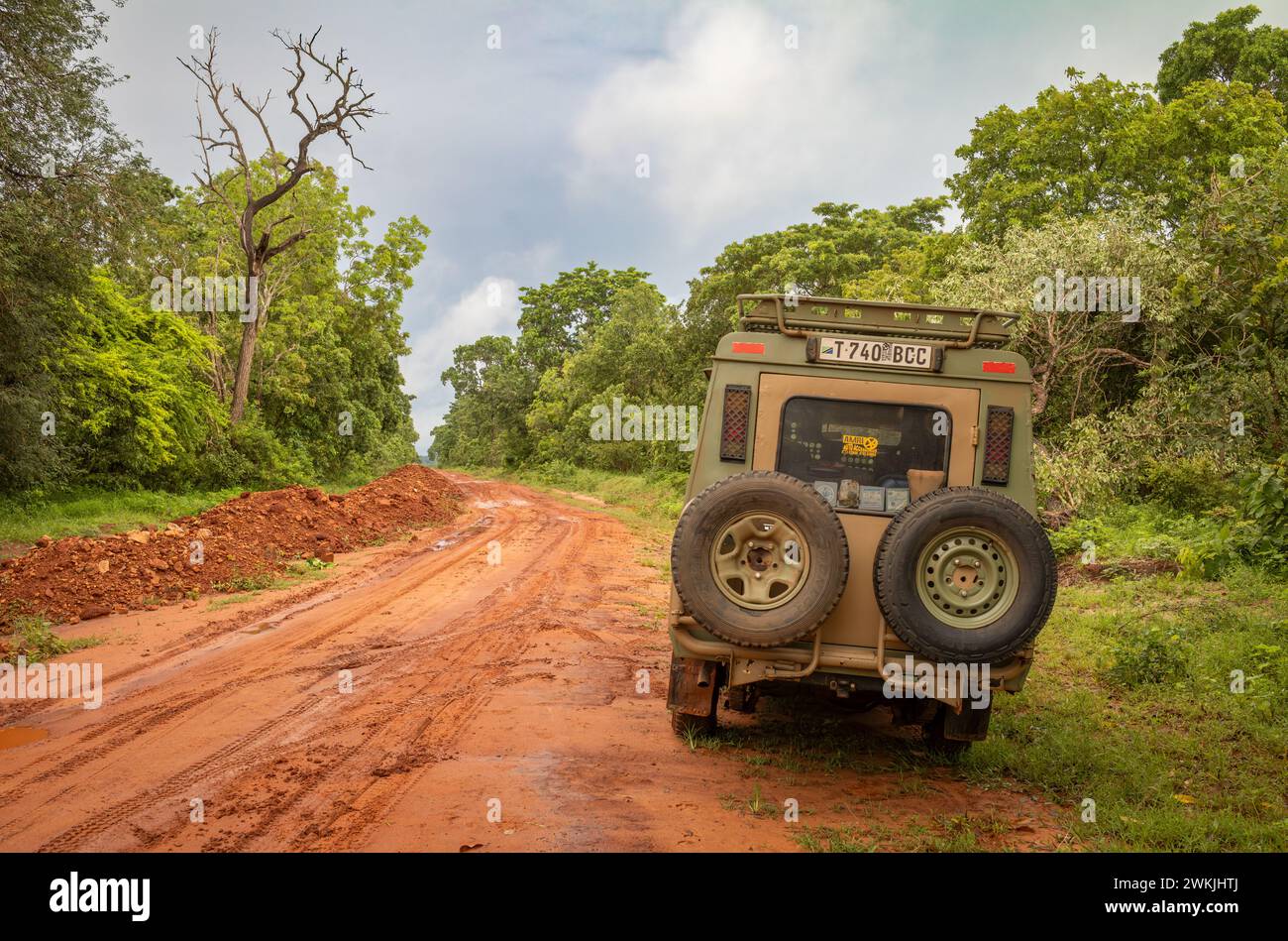 Un véhicule 4x4 sur une route de terre rouge après de fortes pluies dans la nature sauvage près de Cholesamvula en Tanzanie rurale. Banque D'Images