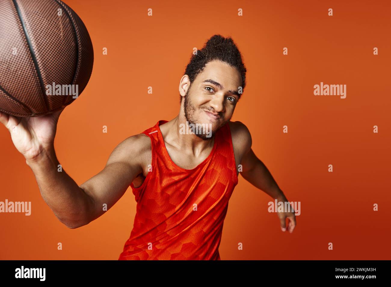 joyeux homme afro-américain en uniforme posant avec le basket-ball et regardant la caméra Banque D'Images