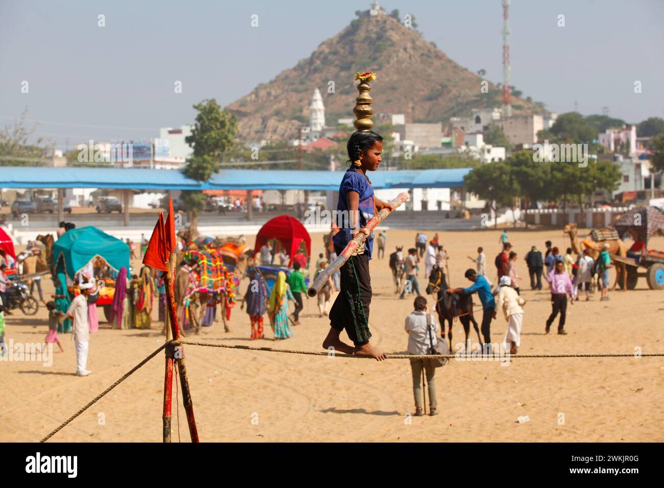Un jeune marcheur de corde tendue équilibré à la foire de chameau de Pushkar, Rajasthan, Inde. Banque D'Images