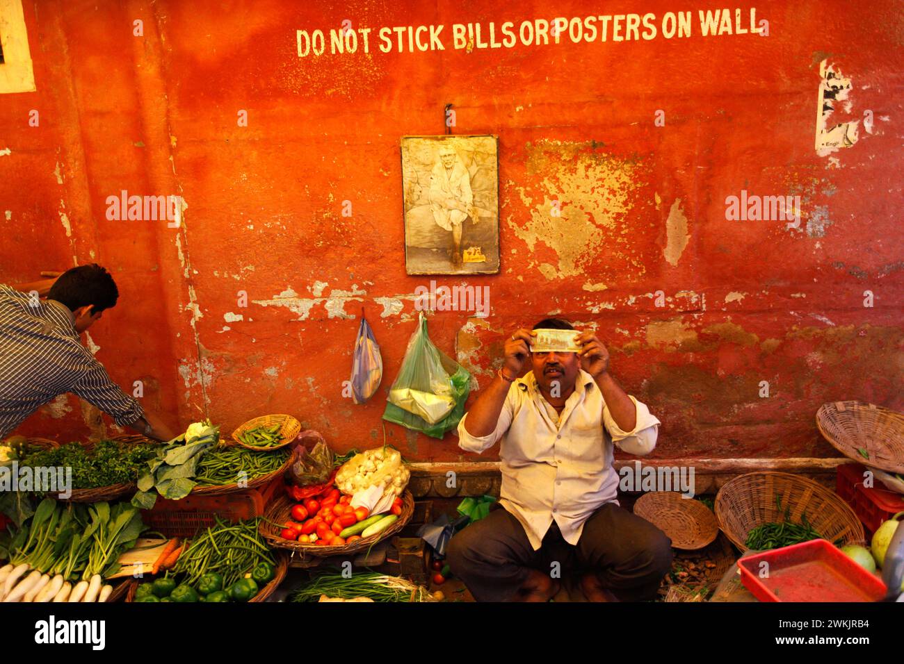 Un commerçant indien vérifie un billet de banque dans une rue de Varanasi, Uttar Pradesh, Inde. Banque D'Images