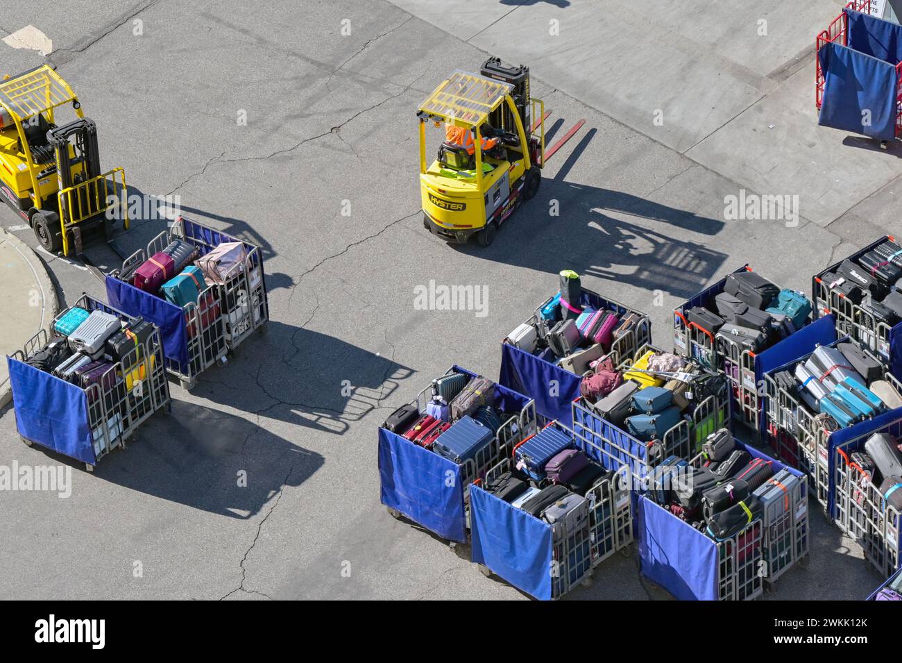 Los Angeles, Californie, États-Unis - 12 janvier 2024 : chariots élévateurs à fourche et chariots à bagages pleins de valises à charger sur un bateau de croisière Banque D'Images