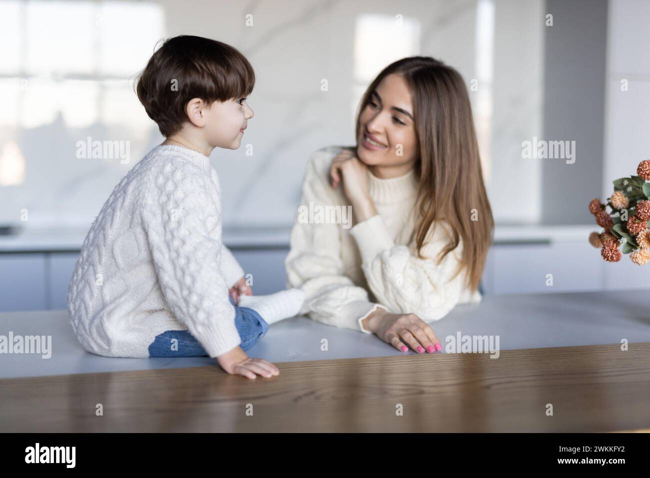 Enfant garçon assis sur les mains d'une jeune femme.sourire de visage de gros plan. Banque D'Images