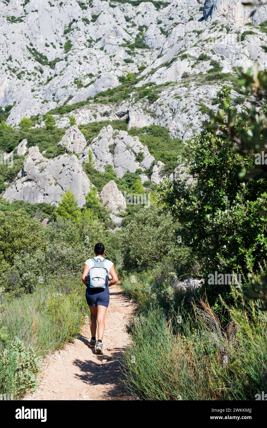 Femme se promène seule dans la forêt du sud de la France, trail trek, vue arrière, personne active Banque D'Images