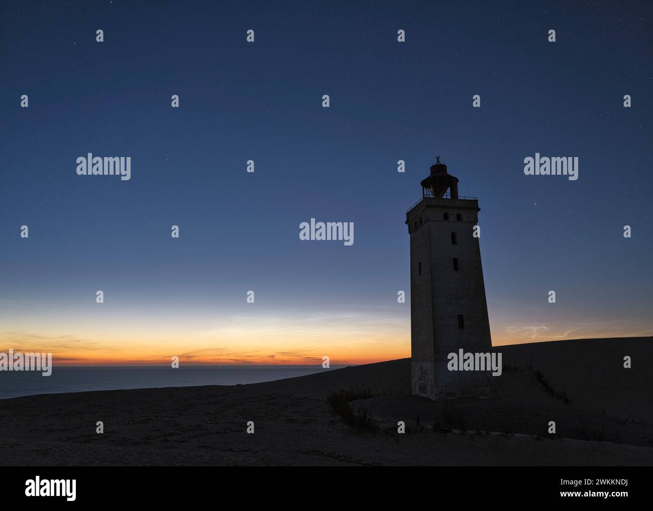 Célèbre phare de Rubjerg Knude sur une dune de sable sous un ciel étoilé avec des nuages noctilucents au crépuscule Banque D'Images