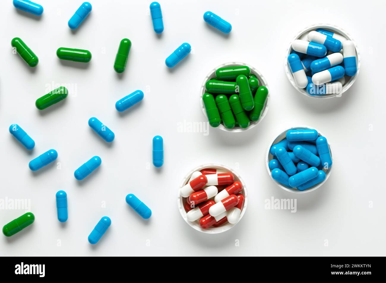 Pilules de médecine sur fond blanc, vue de dessus. Tas de compléments alimentaires, diverses vitamines colorées, capsules médicales pharmaceutiques assorties close-u Banque D'Images