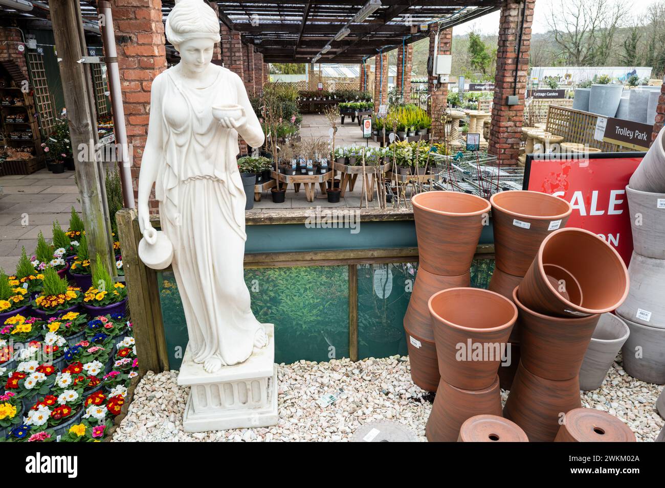 Jardinière pot, fleurs et déesse mythique Hebe à vendre dans le village de Bishopsteignton, Devon, Angleterre. Banque D'Images