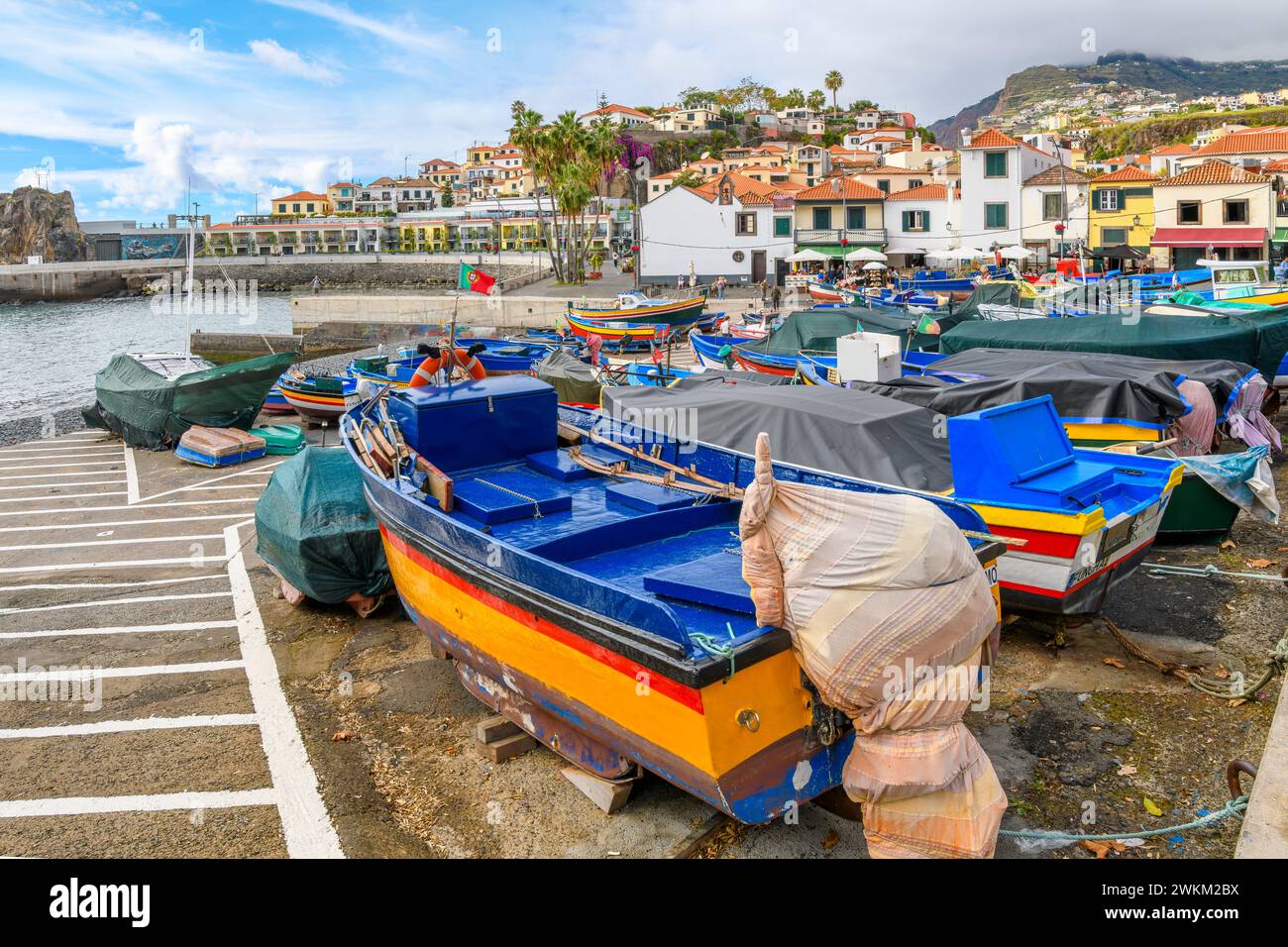 Petits bateaux de pêche colorés de bleu, jaune et rouge bordent le petit port de plaisance du petit village de pêcheurs de Câmara de Lobos, Madère Portugal Banque D'Images