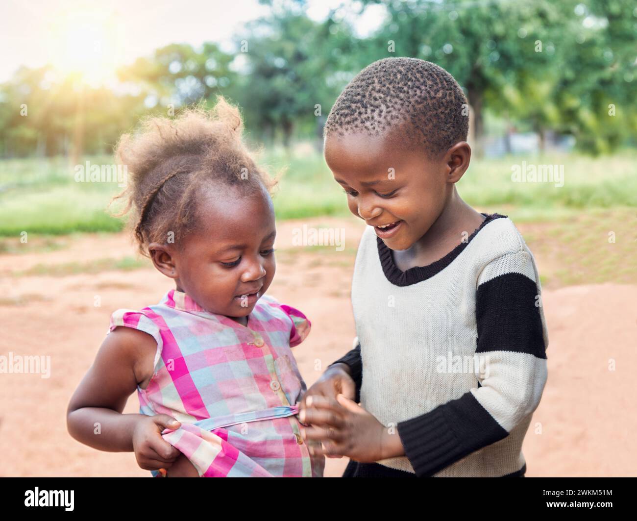 Des ONG bénévoles du monde entier aident les enfants africains. Heureux garçon et fille du village jouant dans la cour. Banque D'Images