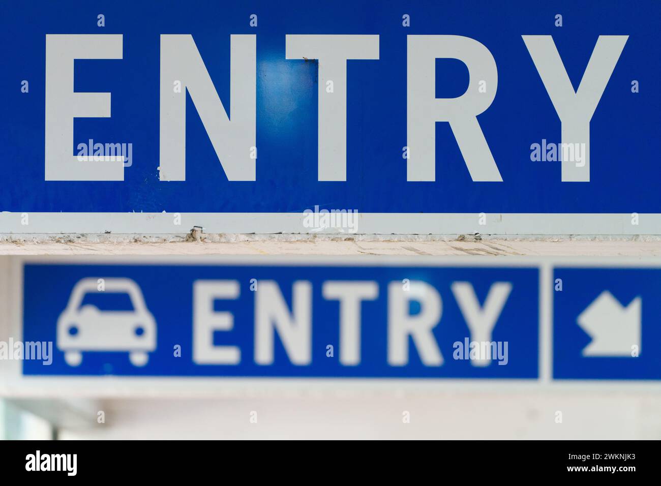 Point d'accès au parking public avec panneau d'entrée, flèche de direction et symbole de voiture, lettrage blanc sur fond bleu, ville de Melbourne, Australie. Banque D'Images