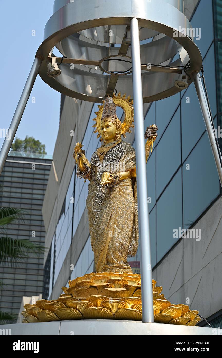 Lakshmi est l'une des principales déesses de l'hindouisme, représentée ici comme une femme élégante et dorée debout sur un lotus dans un sanctuaire de Bangkok Banque D'Images