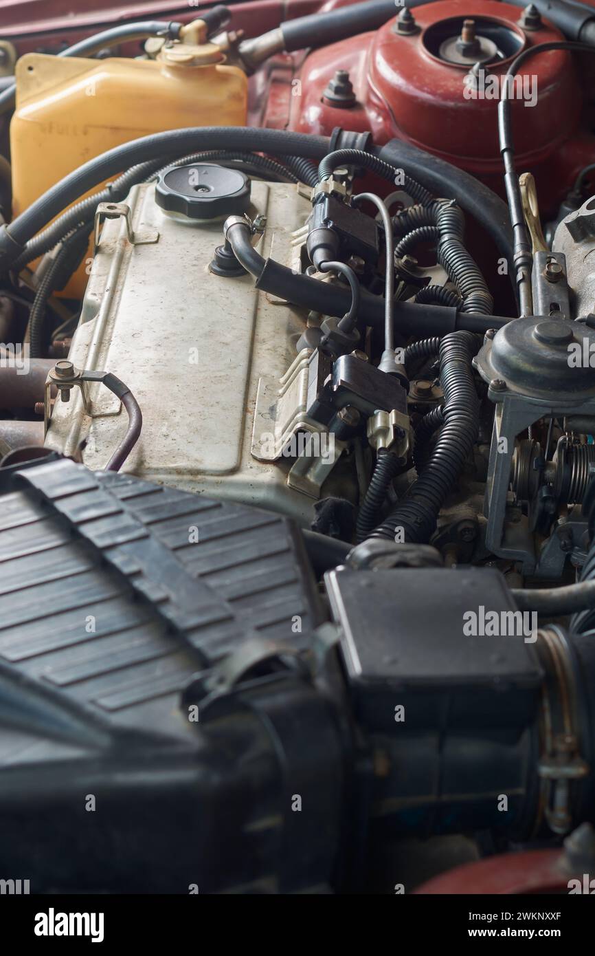 vue latérale du moteur ou du moteur de voiture à quatre cylindres ancien et utilisé, moteur à essence à combustion interne haute performance en ligne droite, mise au point sélective Banque D'Images
