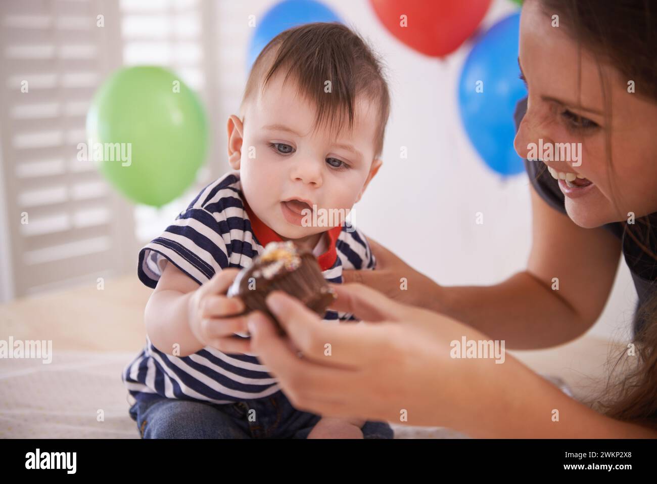 Bébé, mère et fête d'anniversaire avec gâteau ou ballons à la maison pour la célébration d'un jour spécial, décoration ou développement. Enfant, parent et doux Banque D'Images