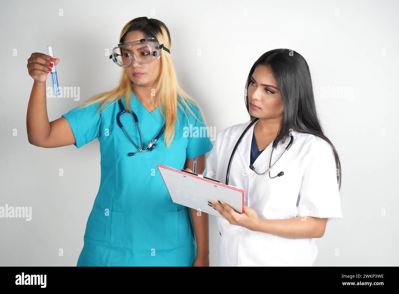 Deux femmes médecins tenant une planche à pince, debout ensemble Banque D'Images