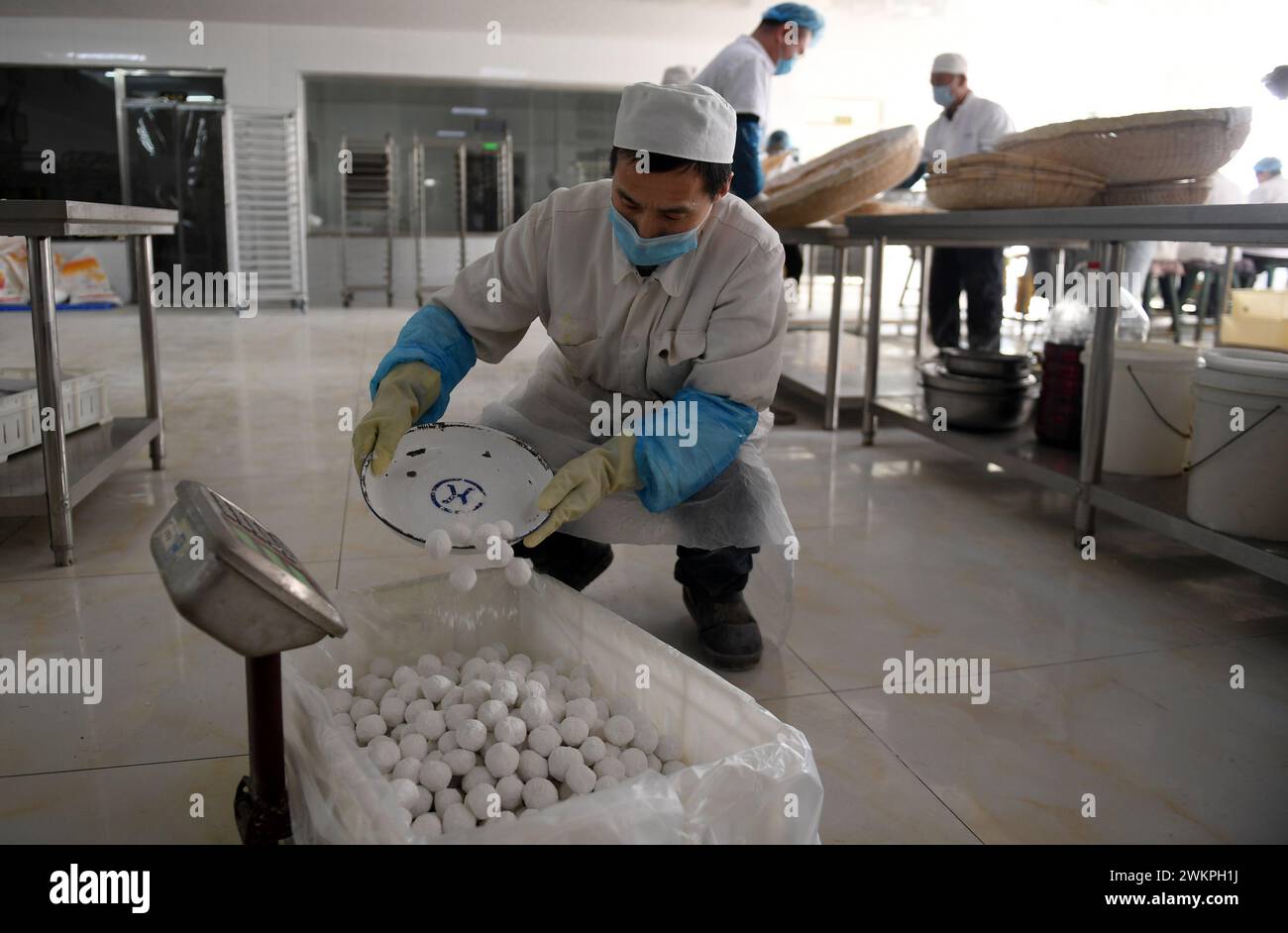 ZHANGJIAKOU, CHINE - 22 FÉVRIER 2024 - des ouvriers fabriquent des boulettes de riz gluantes dans une pâtisserie traditionnelle à Zhangjiakou, dans la province du Hebei, au nord de la Chine. Banque D'Images