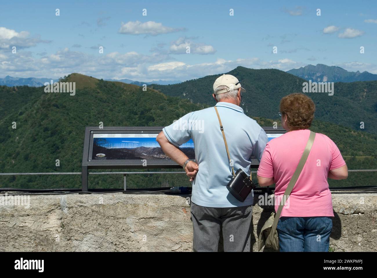 Couple de touristes regardant un panneau de panorama et paysage de montagne du parc régional Campo dei Fiori de Sacro Monte de Varèse, Lombardie, Italie Banque D'Images