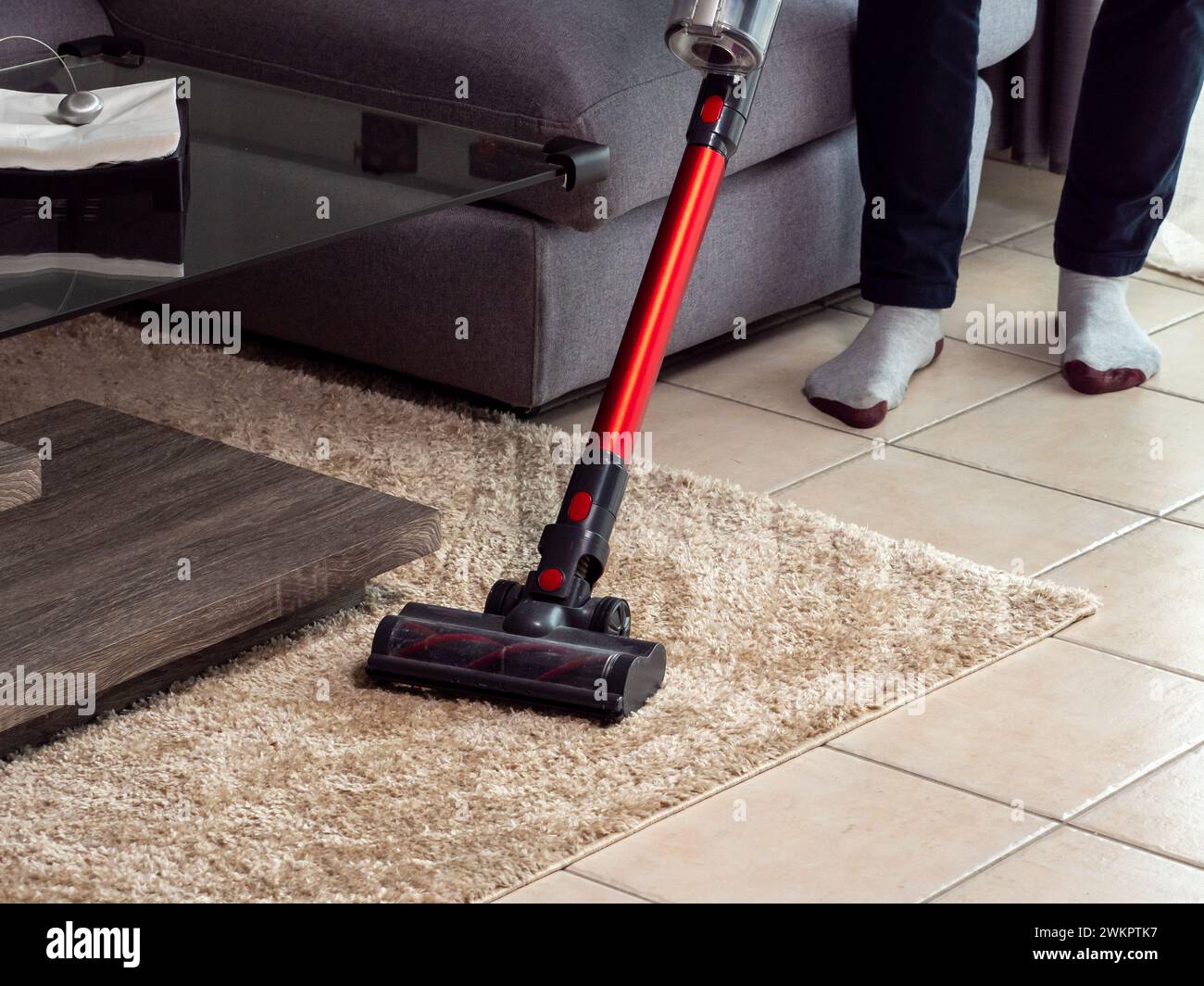 passer l'aspirateur sur le trottoir à la maison avec un aspirateur à main, ranger l'appartement Banque D'Images