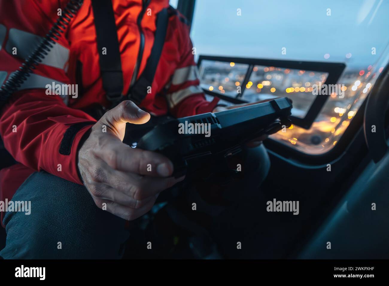 Gros plan des mains du médecin à l'intérieur du service médical d'urgence de l'hélicoptère tout en utilisant la tablette numérique pendant un vol de mission de nuit. Banque D'Images