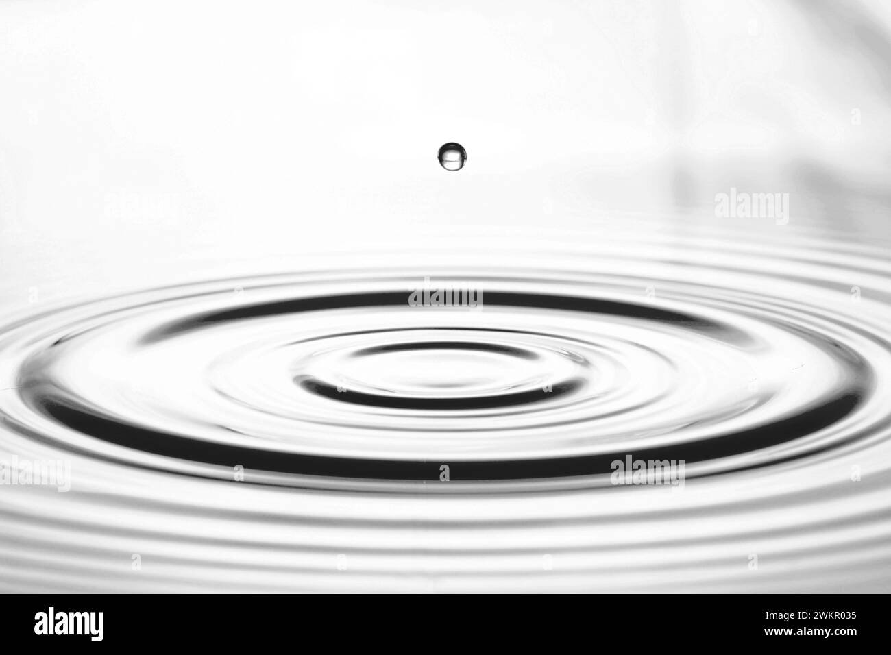 une goutte d'eau saute vers le haut de la surface de l'eau Banque D'Images