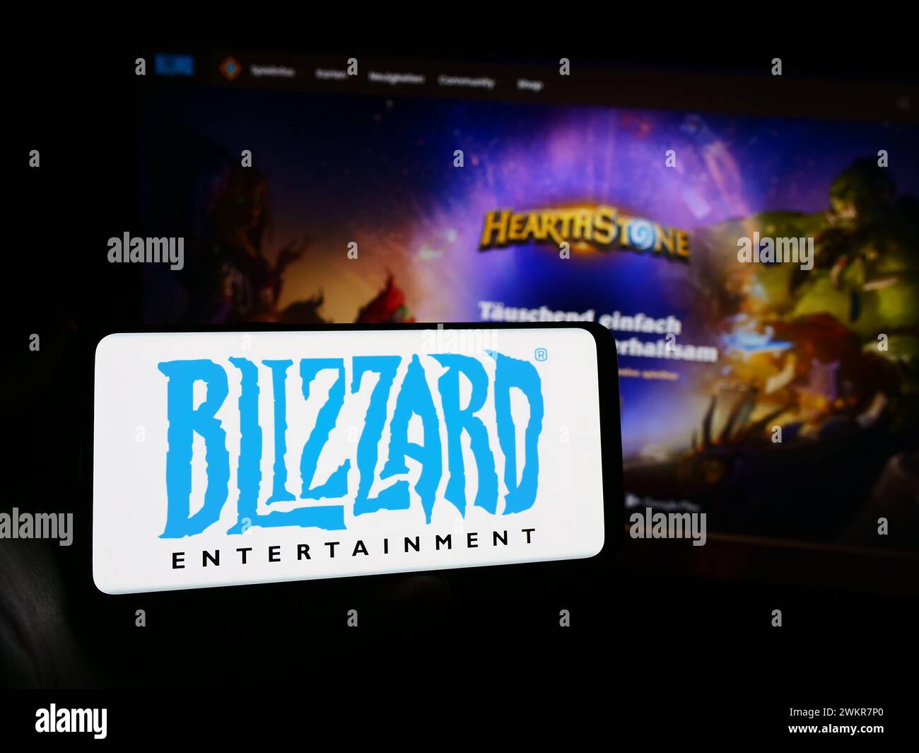 Personne tenant le téléphone portable avec le logo de la société américaine de jeux vidéo Blizzard Entertainment Inc en face de la page Web. Concentrez-vous sur l'affichage du téléphone. Banque D'Images