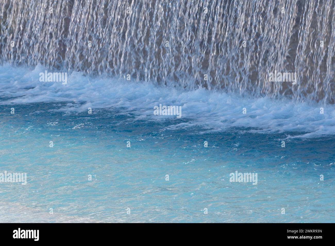 De l'eau glacée s'écoulant d'un barrage dans la piscine bleue Banque D'Images