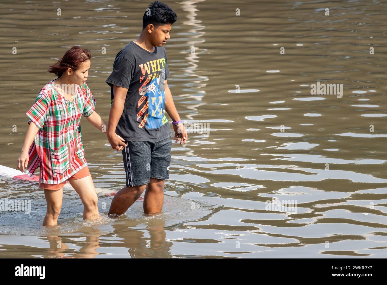 SAMUT PRAKAN, THAÏLANDE, février 02 2024, Un couple patente dans une rue inondée Banque D'Images
