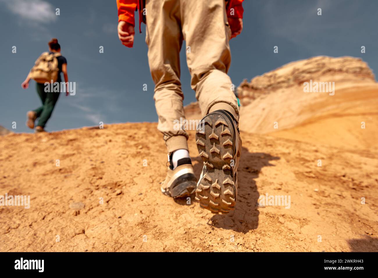Photo rapprochée de jambes et de bottes de randonneur marchant en montée Banque D'Images