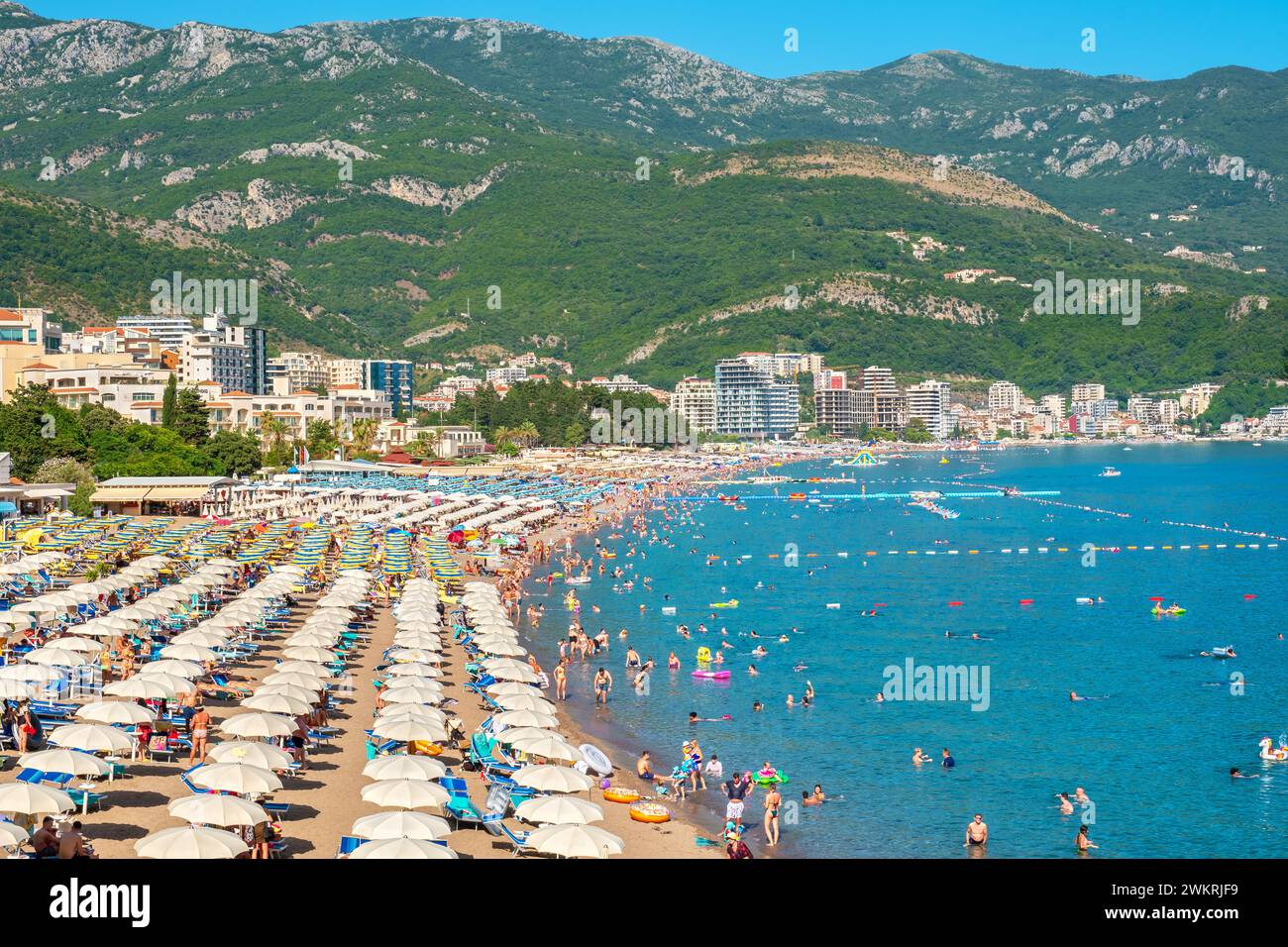 Les gens se relaxent sur la longue plage de sable fin pendant les vacances d'été. Becici, Monténégro Banque D'Images