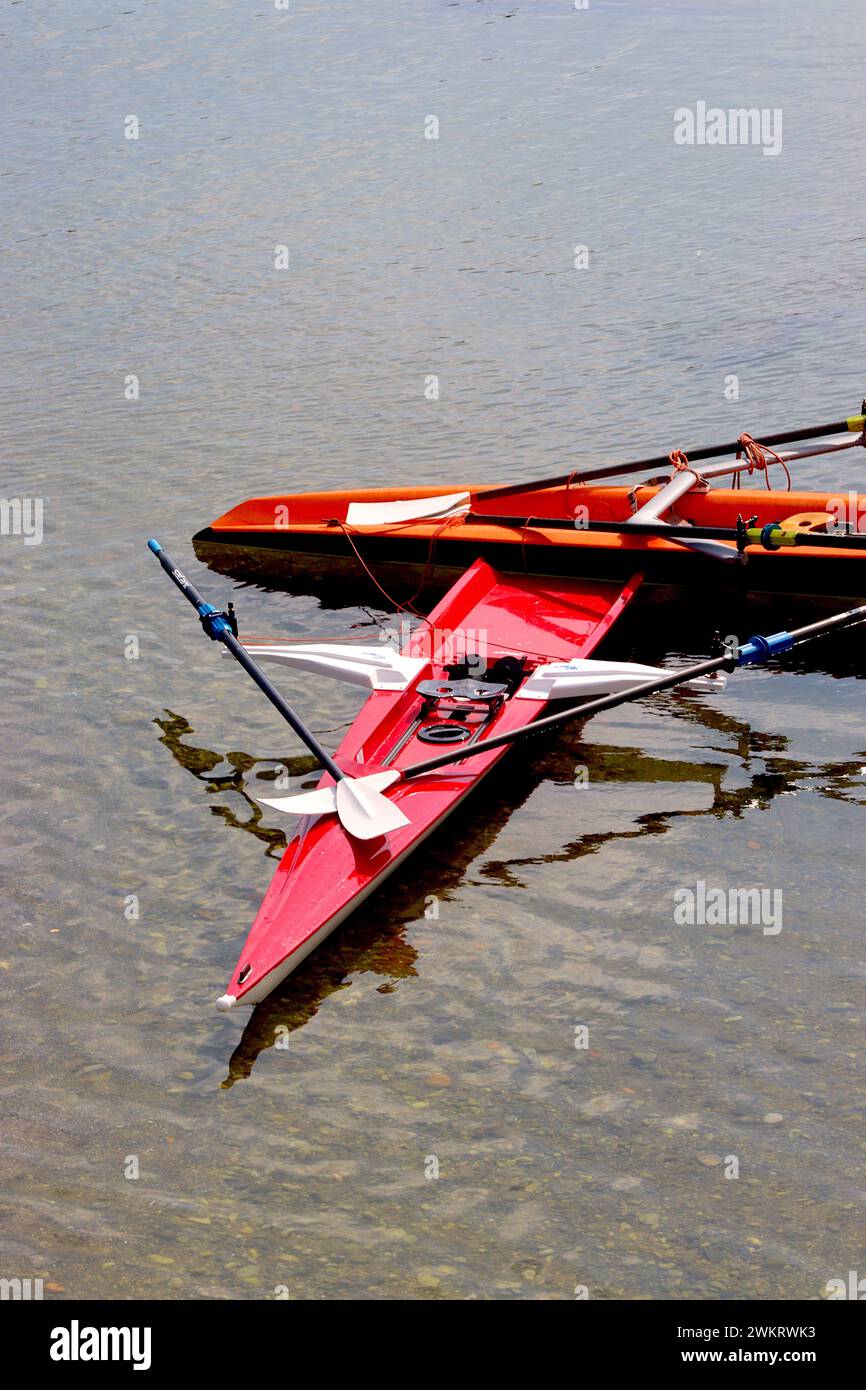 Deux bateaux à rames pour sports de loisir à une seule échassière laissés en eau peu profonde tandis que leurs propriétaires cherchent des rafraîchissements sur l'esplanade de Salerne, en Italie. Banque D'Images