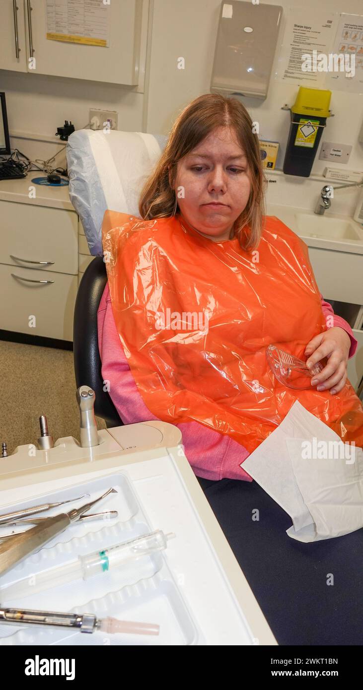 la patiente dans la chaise de dentistes a une extraction de deux dents de sagesse. Banque D'Images