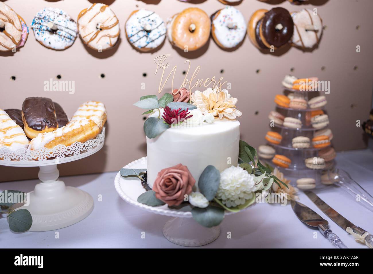 Un gâteau de mariage avec un mur beignet et des macarons Banque D'Images