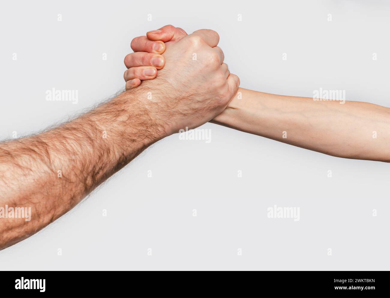 Homme et femme avec les mains serrées s'engagent dans la lutte au bras. Fond gris. Luttez homme et femme Banque D'Images