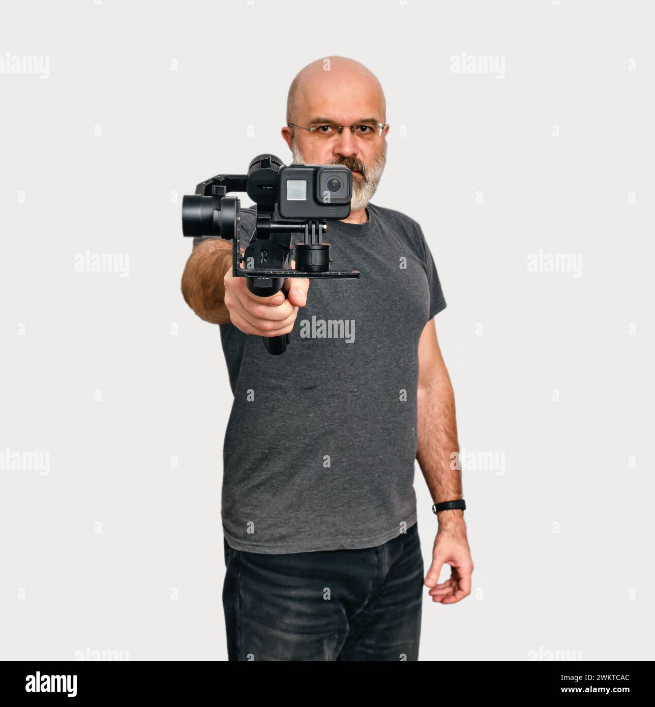 L'homme tient un stabilisateur vidéo-photo portable moderne. Fond blanc. Vlog et concept de blog vidéo Banque D'Images