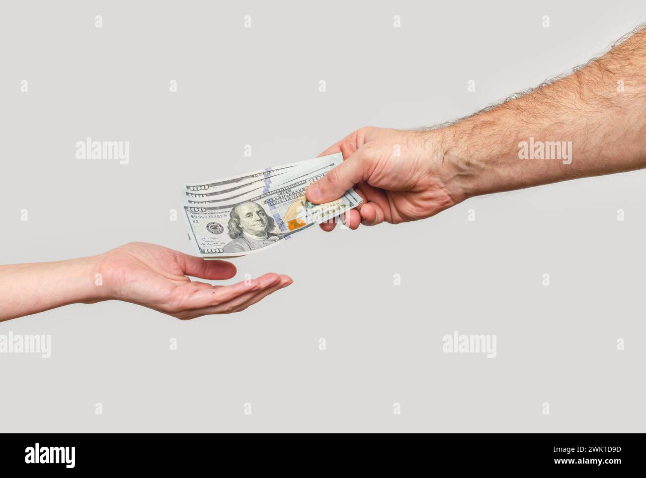 Main masculine envoie les billets de banque à la main de la femme. Transfert d'argent, parrainage, relations financières. Banque D'Images