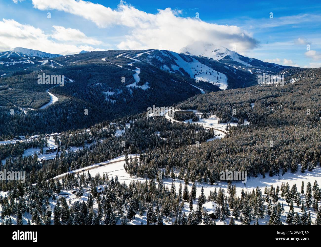 Vue aérienne route de circulation à travers les montagnes enneigées avec des pins Banque D'Images