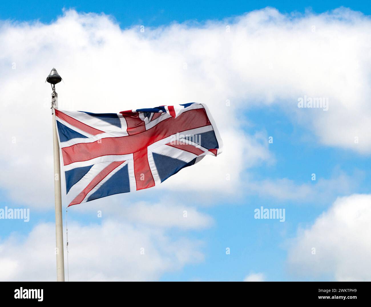 union jack volant d'un poteau avec sjy bleu en arrière-plan Banque D'Images