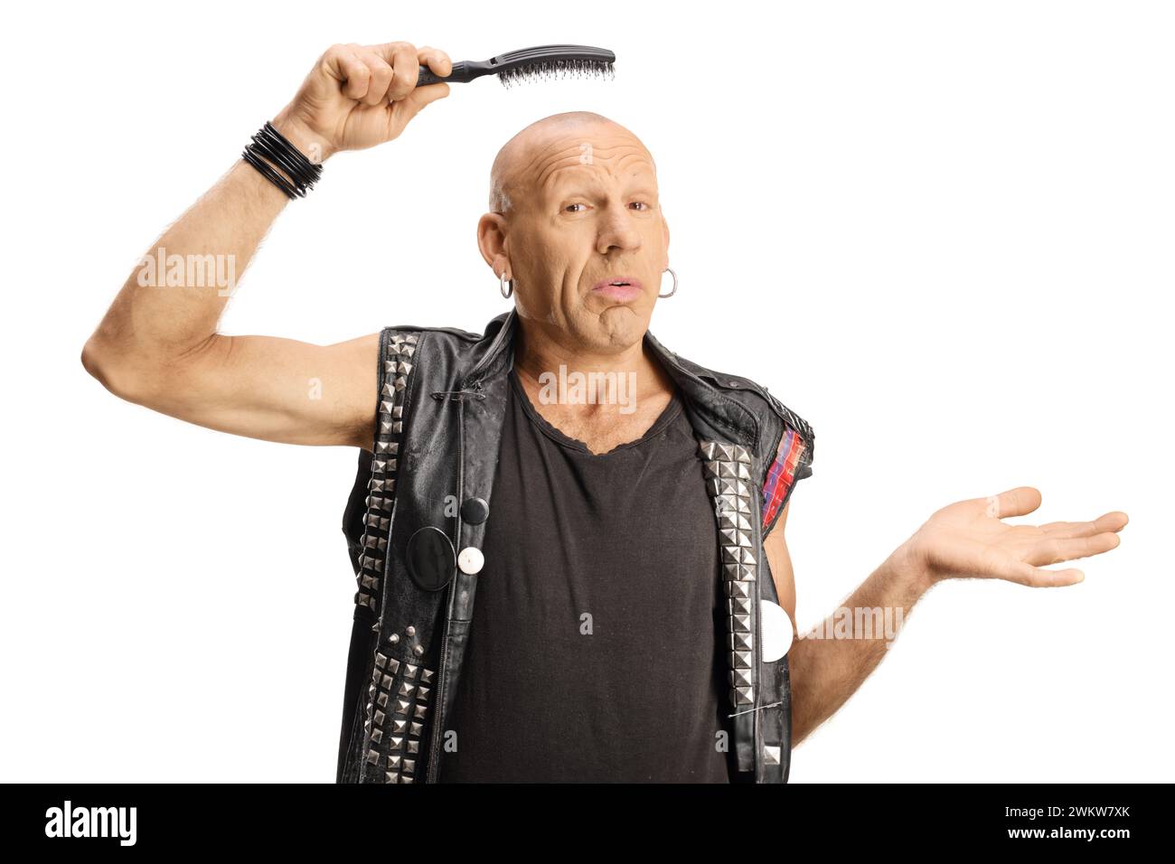 Homme confus tenant une brosse à cheveux au-dessus de sa tête de bals isolé sur fond blanc Banque D'Images