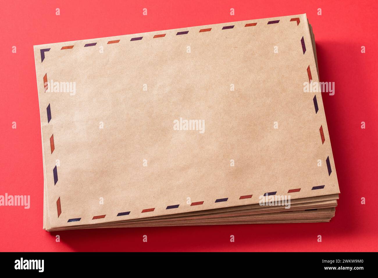 Pile d'enveloppes de vœux vides sur un fond rouge, modèle pour le concepteur Banque D'Images