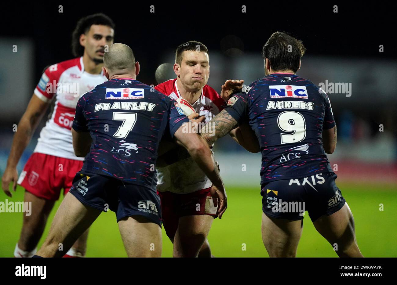 Tom Opacic de Hull KR est attaqué par Matt Frawley de Leeds Rhino (à gauche) et Andy Ackers lors du match de Betfred Super League au Sewell Group Craven Park Stadium, Kingston upon Hull. Date de la photo : jeudi 22 février 2024. Banque D'Images