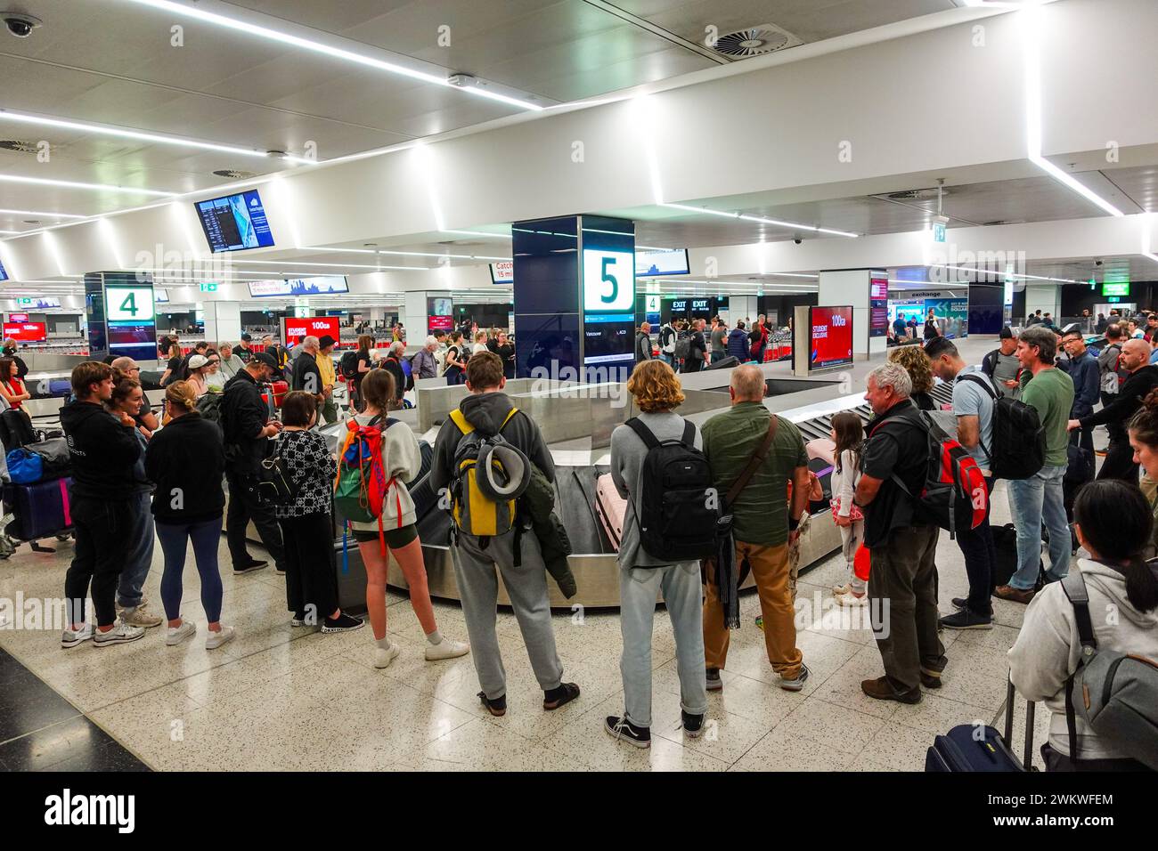 Voyageurs attendant leurs bagages à l'intérieur de l'aéroport international de Sydney Banque D'Images