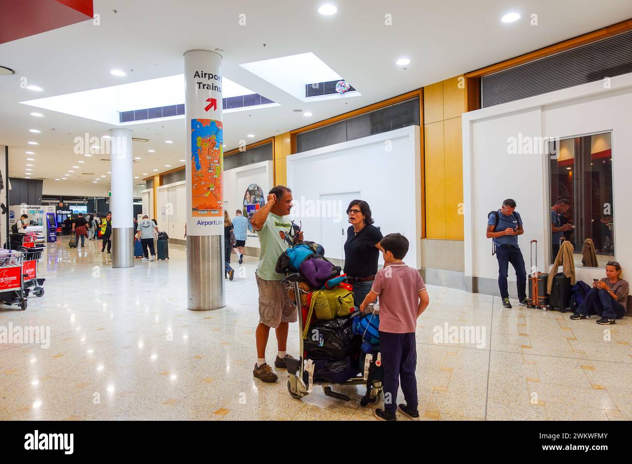 Une famille de trois personnes a engagé une conversation à l'intérieur de l'aéroport international de Sydney Banque D'Images