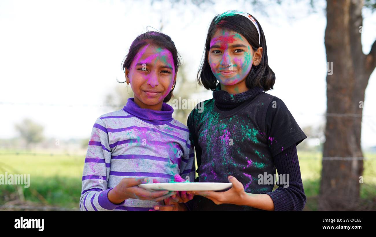 Heureux enfants indiens jouant des couleurs, souriant avec des couleurs sur le visage ou enfants asiatiques célébrant Holi. Concept pour le festival indien Holi. Des taches brillantes pour les enfants Banque D'Images