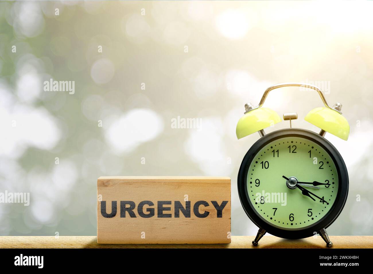 Le réveil avec texte d'urgence sur le bloc de bois sur la table. Concept d'urgence Banque D'Images