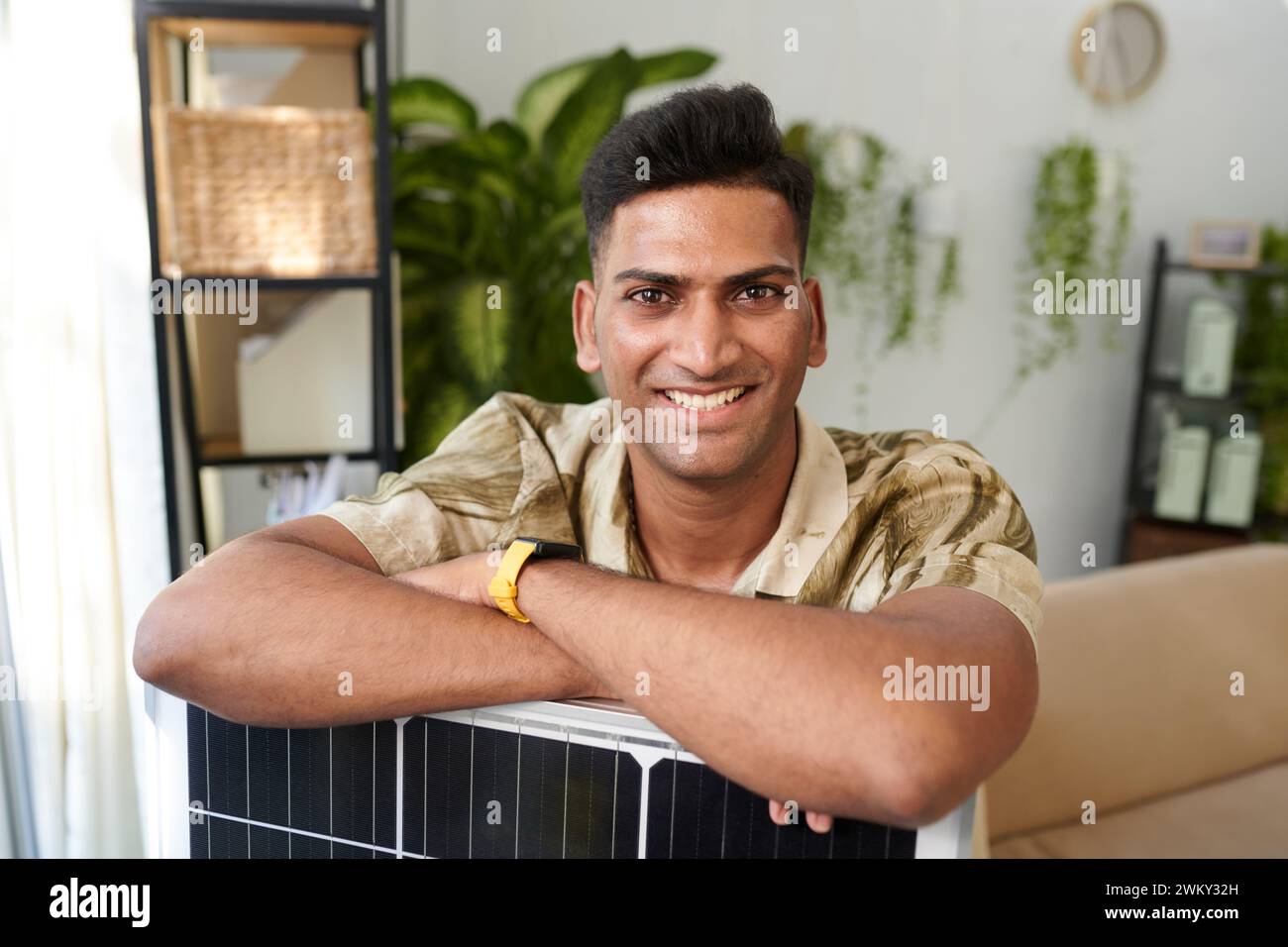 Portrait de l'homme heureux appuyé sur le panneau solaire qu'il a acheté Banque D'Images