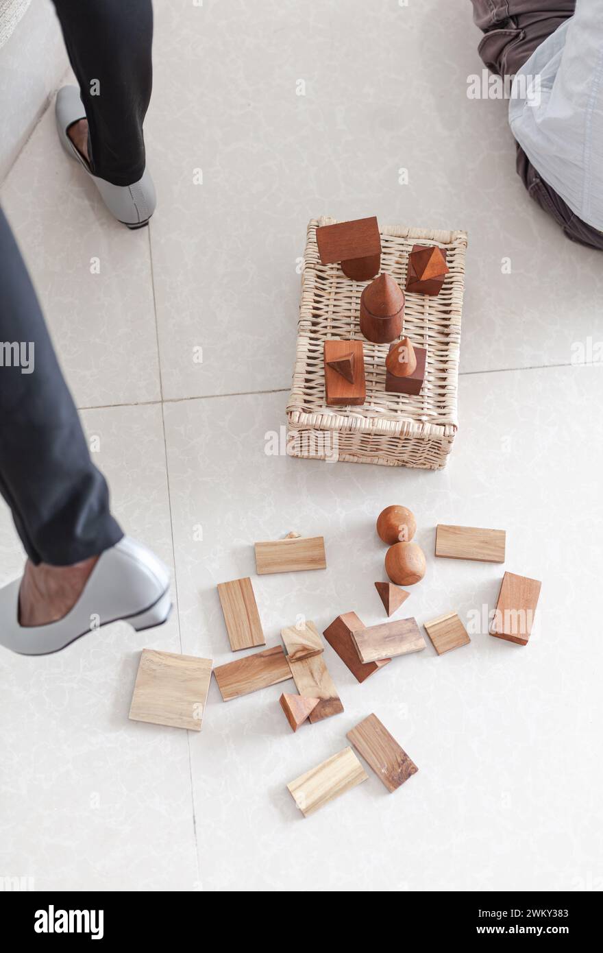 Les gens jouant des blocs de construction en bois jouets ensemble dans un intérieur minimaliste léger Banque D'Images