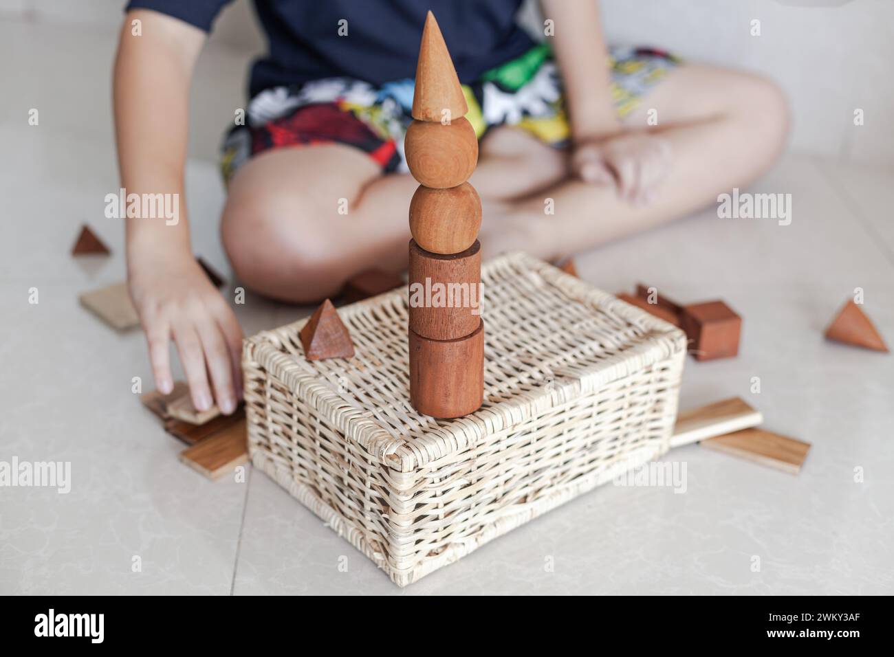 Un enfant jouant avec des jouets de blocs de construction en bois dans un intérieur minimaliste léger Banque D'Images