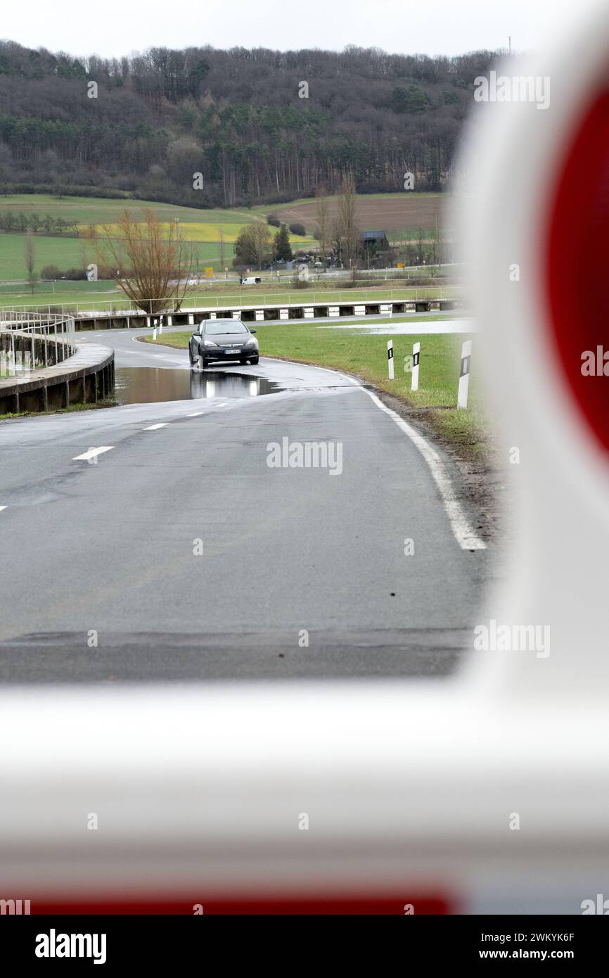 Hemmendorf, Allemagne. 23 février 2024. Une voiture se dirige vers une route inondée entre Lahm (district de Coburg) et Hemmendorf (district de Haßberge). À l'écartement Schenkenau, le niveau d'inondation 2 s'applique et de nombreuses routes traversant l'Itz sont déjà fermées. Crédit : Pia Bayer/dpa/Alamy Live News Banque D'Images