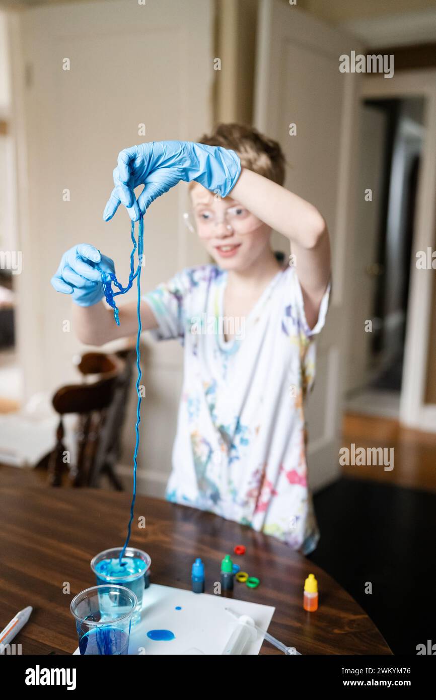 Boy joue avec Jelly Worms Made from Home Science Project Banque D'Images